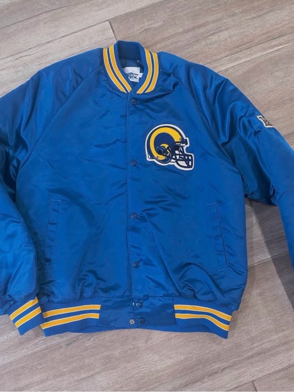 This is a vintage Chalk Line Los Angeles Rams blue satin bomber jacket size L